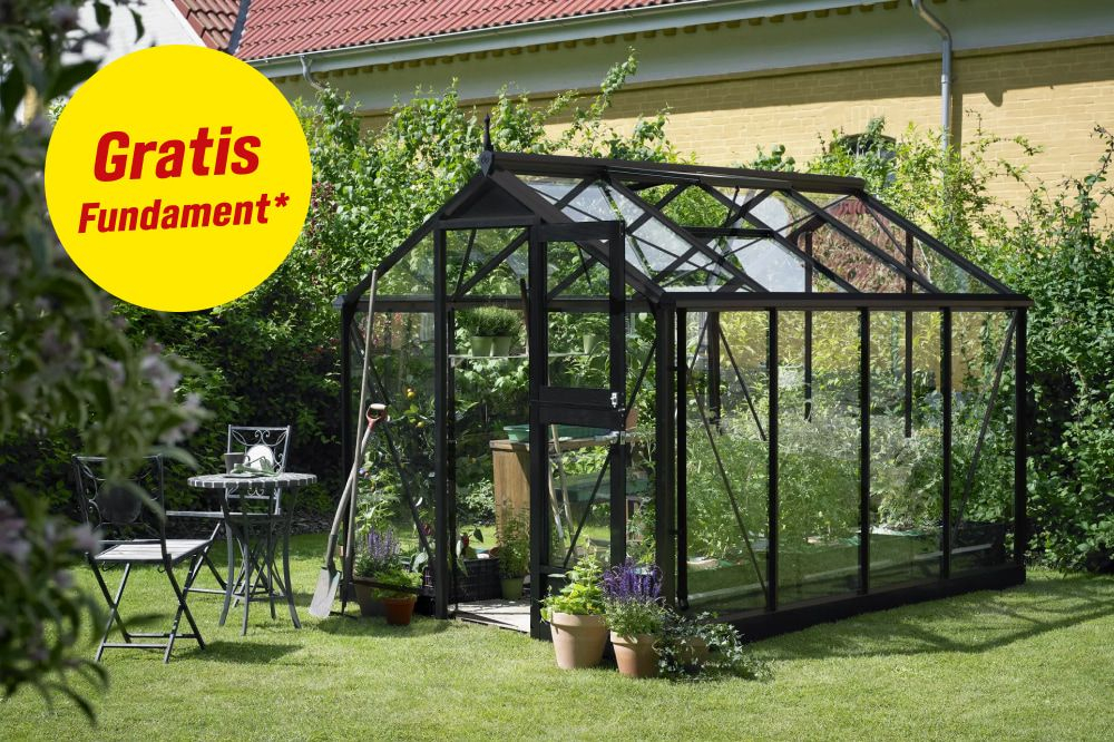 Gewächshaus im grünen Garten. Hinweis Gratis Fundament